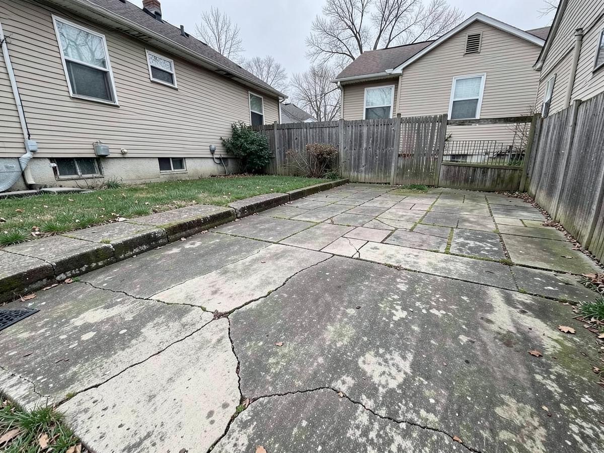 Cracked and stained concrete slab patio before replacement